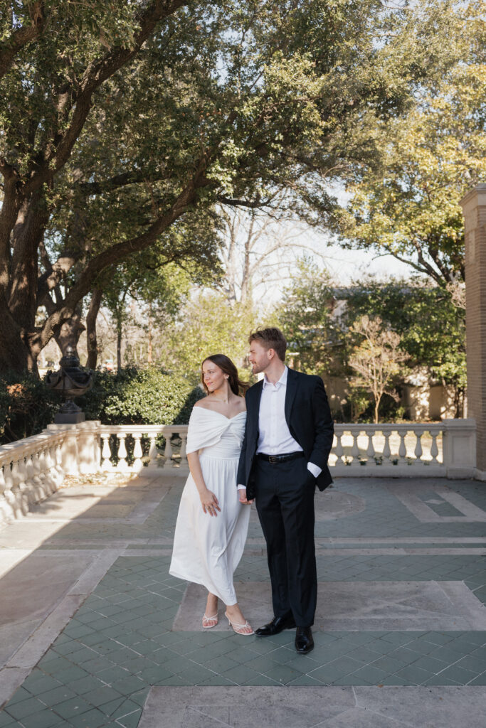 Engaged couple under trees at The Aldredge House grounds

